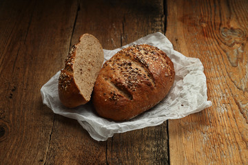 Bread with butter-paper on wooden background
