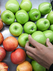 Women are picking apples in the market.