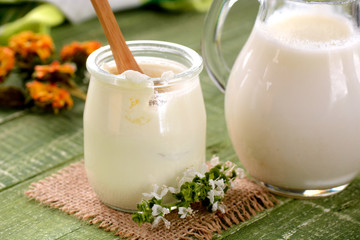 yogurt bianco nel vasetto di vetro sul tavolo verde