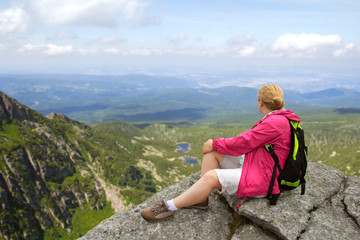 Naklejka premium hiker relaxing on the mountain rock