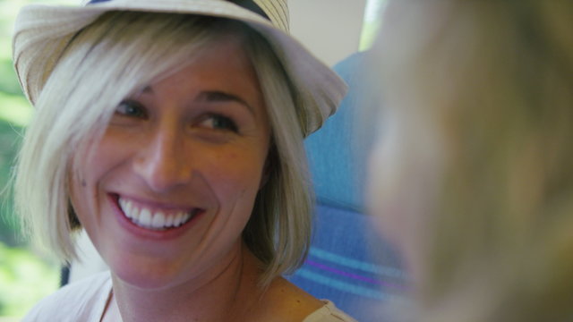 Young couple on a train cheerfully talk on their journey in slow motion
