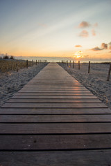 wooden walkway to beach at sunset