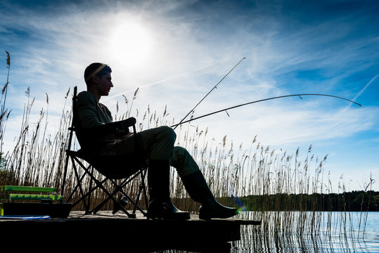 Fisherman or Angler at lake in Sunrise backlit