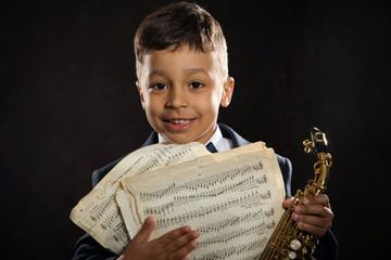 six years old boy sit with saxophone