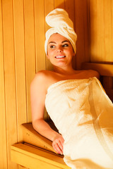 woman sitting relaxed in wooden sauna