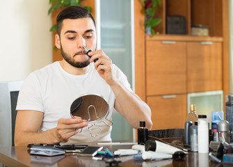 Young man using hair trimmer