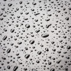 Macro water drop on black stone texture