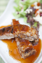 Pork rib stack with red sauce with salad
