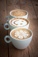 Three coffee cups on wooden background