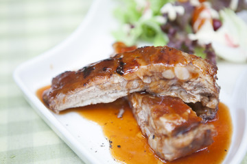 Pork rib stack with red sauce with salad