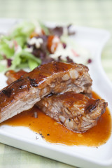 Pork rib stack with red sauce with salad