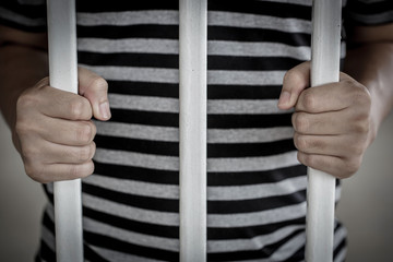 The Asian prisoner standing behind the jail