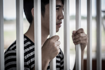 The Asian prisoner standing behind the jail