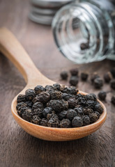 Black pepper on wooden spoon