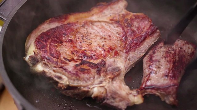 HD 1080 static: Bone steak  baking in frying pan; close up; 