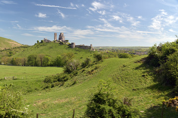 Corfe Castle seen across fields in Dorset