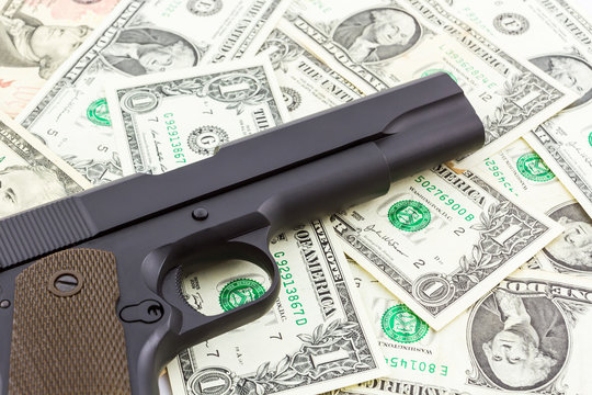 Gun on money texture background.