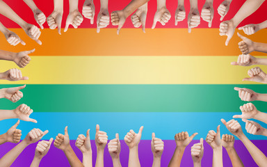 hands showing thumbs up in circle over rainbow