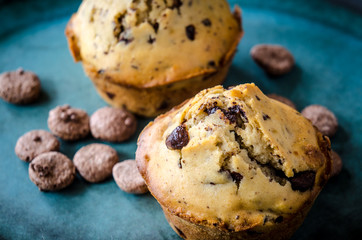 Muffins mit Schokolade und Kekse auf blauem Teller