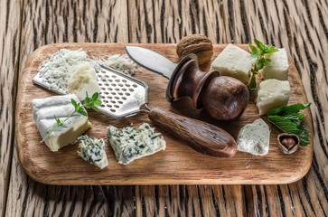 Different types of cheeses with nuts and herbs.