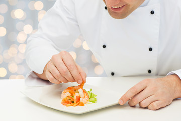 close up of happy male chef cook decorating dish