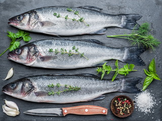 Seabass on a graphite board with spices and herbs.