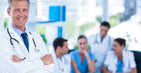 Doctor smiling at camera with colleagues behind