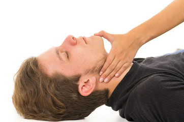 Couple demonstrating first aid techniques with male patients head being tilted slightly backwards...
