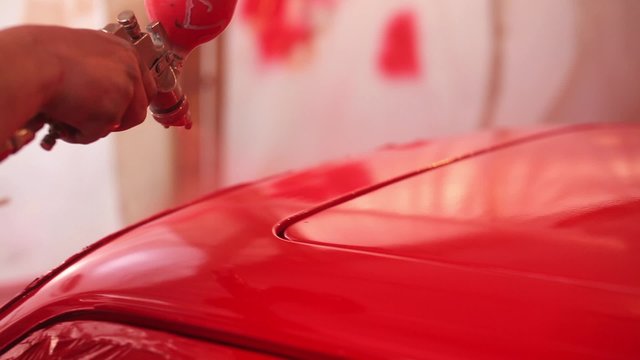 Painter paint the red car in garage
