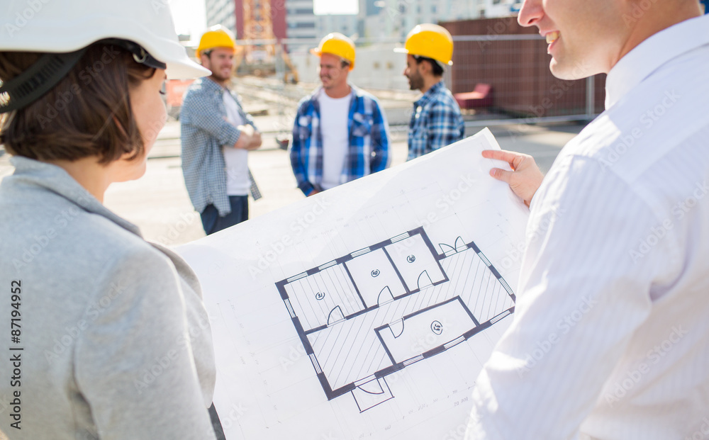 Wall mural close up of architects with blueprint at building