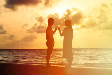 Fototapeta premium Silhouette of couple drinking wine at sunset