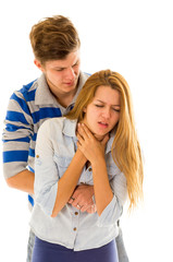 Couple demonstrating first aid techniques by man performing heimlich on female choking