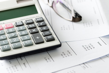 Financial statement with calculator and glasses