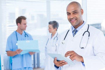 Smiling doctor using his tablet