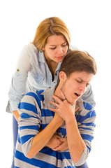 Couple demonstrating first aid techniques with woman performing heimlich in male choking