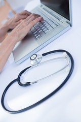 Close up view of female doctor using laptop 