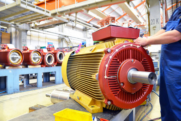 Maschinenbau, Arbeiter montiert Elektromotor in einer Fabrik // Engineering, workers mounted electric motor in a factory - obrazy, fototapety, plakaty