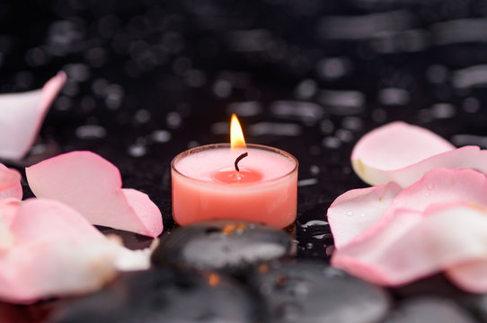 petals with pink candle and therapy stones 