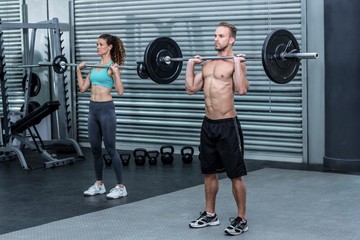 Fototapeta na wymiar Muscular couple lifting weight together
