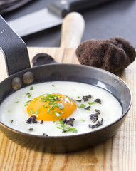 Fried egg with truffle and parsley in a frying pan. © hansgeel