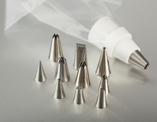 Pastry bag with tips on stainless steel surface.