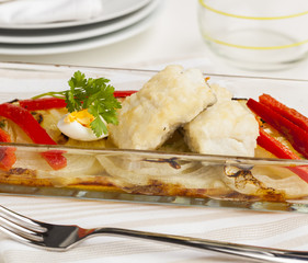 Cod fillet with onions, bell pepper and egg.