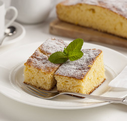 Two slices of homemade cake with powdered sugar.
