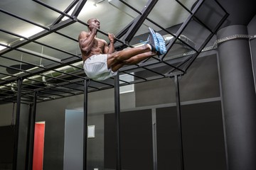 Young Bodybuilder lifting himself up and down