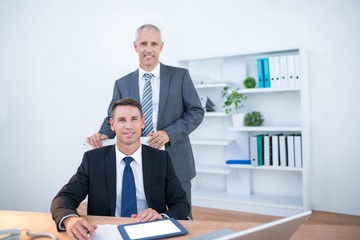 Happy colleagues working together on digital tablet 