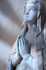 Moonlit Madonna. Moonlight falling on the face and hands of a statue of the Madonna at prayer. © pxl.store