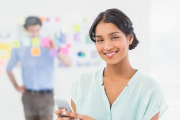 Businesswoman having phone call while her colleague posing