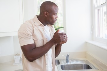 A man taking his tea and looking outside