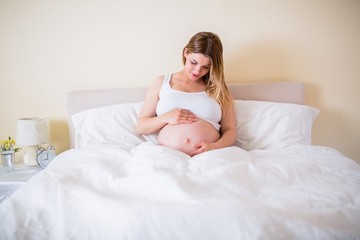 Pregnant woman looking at her belly 