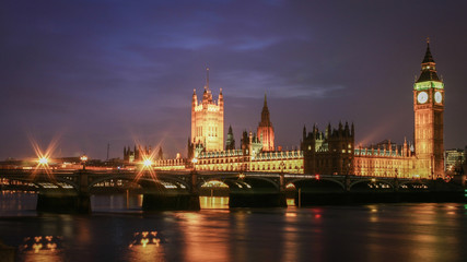 Fototapeta na wymiar Houses of Parliament at night. Night view of the seat of UK government, The Houses of Parliament, viewed from across the River Thames and with Westminster Bridge in the foreground.